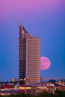High-rise in Leipzig beneath the full moon, calm nighttime atmosphere.