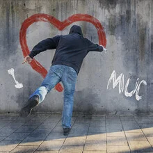 Man sprays a heart in the sun, graffiti in Munich, relaxed atmosphere