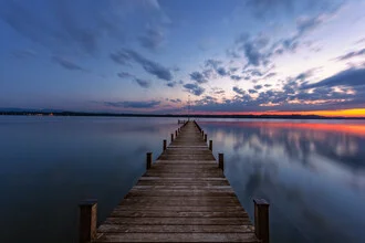 Sonnenuntergang am Starnberger See mit sanften Wellen und warmen Farben.