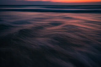 Sanfte Wellen bei Sonnenuntergang, die ruhige Atmosphäre des Meeres einfangend.