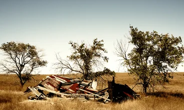Photo art by Holger Ostwald: scene of homelessness with a collapsed door and trees