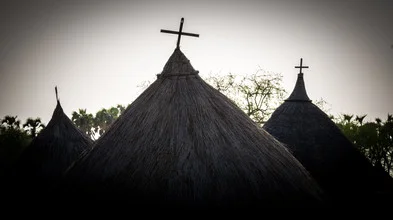 Photo art by Ulrich Kleiner: a Christian hut in South Sudan surrounded by trees