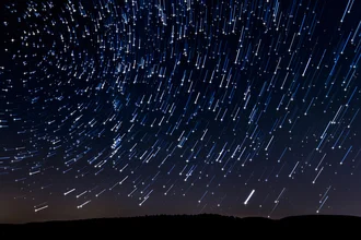 Photo art by Dennis Oswald: abstract night scene with star trails over mountains
