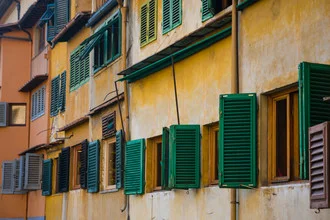 Colorful windows with shutters in an Italian backyard.