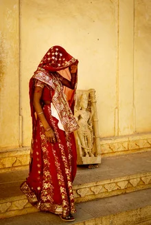 Fotokunst eines Frauenportraits in einem roten Sari, warmes Licht und kulturelle Atmosphäre.