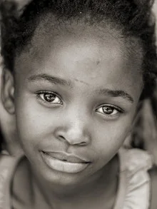 Close-up of a smiling girl from Namibia with bright eyes.