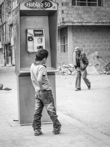Fotokunst von Jonas Schleske: Ein Junge telefoniert auf der Straße in Bogotá.