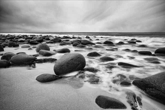 Pebble beach in Norway: gentle waves and gray stones beneath a clear sky