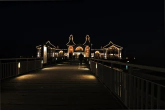 Night photo of the pier in Sellin, gentle waves and calm atmosphere
