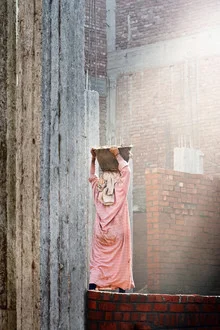 Photo art: Woman carries a heavy load on her head in traditional attire