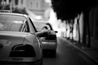 Wandbild von Nasos Zovoilis: Hand mit Zigarette auf einer Straße in Athen