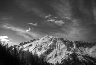 Photo of a mountain in Austria with soft clouds and a calm atmosphere.