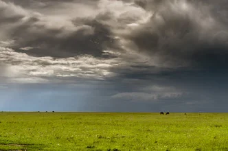 Fotokunst von Ralf Germer: Sonnenstrahlen durch Regenwolken über der Masai Mara