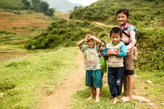 Kinder in SaPa, Vietnam: fröhliche Kinder spielen in einer Reisfeldlandschaft.