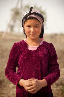 Portrait of a girl in the desert of Uzbekistan, warm light and soft colors.