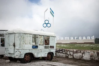 An old vehicle against a striking mountain landscape in Uzbekistan.