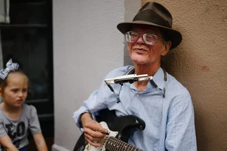 Portrait of an old musician in New Orleans playing guitar on the street.