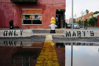 Photo art: Reflection of a red house in a puddle on the street in New Orleans
