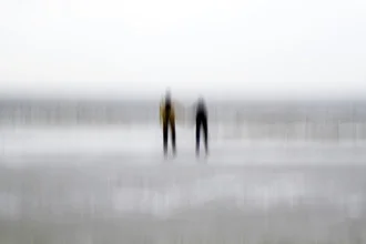 Blurred view of the North Sea coast with people in the distance.