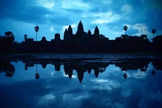 Fotokunst von Axel Bückert: Silhouette von Angkor Wat beim Sonnenaufgang über ruhigem Wasser.
