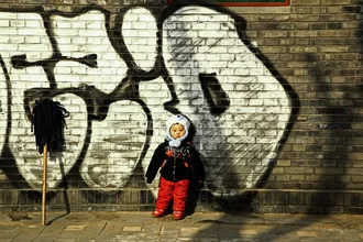 Photo art by Gloria Jansen: child with a dust mop in front of graffiti in winter sunlight