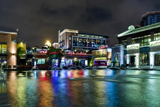 Colorful night photo of the docks in Shanghai with vibrant lights.
