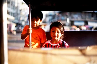 Fotokunst von Jim Delcid: Kinder spielen in einem Tuk Tuk in Phnom Penh, Kambodscha.