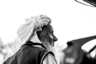 Portrait of an old man from Pakistan looking calmly at the camera with a gentle smile.