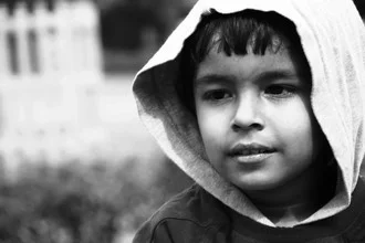A smiling Indian child with bright eyes and a cheerful expression.
