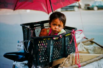 Photo art by Jim Delcid: girl with an umbrella and basket in Cambodia