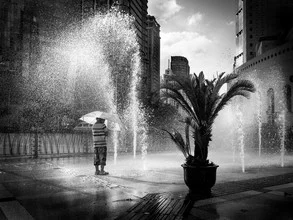 Clear photo of a joyful child playing in a fountain in Shanghai.