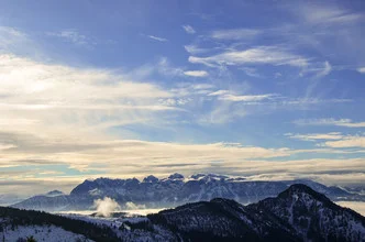 Fotokunst: Sonnenlicht über einem Berggipfel unter blauem Himmel.
