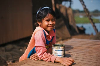 Fotokunst von Jim Delcid: Kind in Kampong Phluck, ruhige Atmosphäre am Wasser.