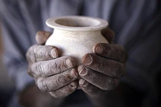 Close-up of hands holding an alabaster vase