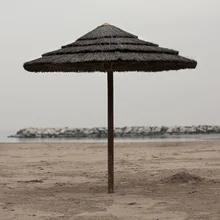Beach umbrella on Rimini's beach, calm atmosphere and soft sand texture.
