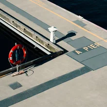 Photo art of a serene pier with a life saver in the shadow