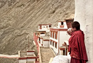 Monk at Rizong Monastery, surrounded by calm nature and spiritual ambiance.