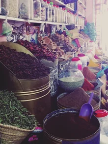 Photo of colorful spices at a market in Marrakech, vibrant colors and an oriental atmosphere.