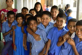 Photographic depiction of children in a school in Bangladesh, cheerful atmosphere.