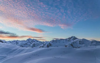 Fotokunst von Christian Schipflinger: sanfter Sonnenaufgang über schneebedeckten Bergen