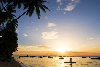 Photo art by Jonas Bach: sunset over calm sea with palm trees.