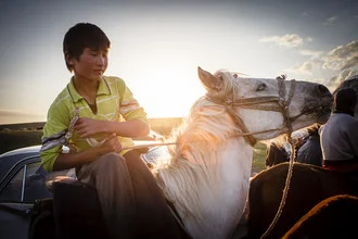 Photo art by Michael Schrenk: boy on a horse at Song Kul Lake during sunset.