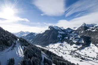 Photo art by Jonas Bach: paragliding over snow-covered mountains in Switzerland