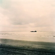 Photo art by Sylvia Landeck: cargo ship on calm North Sea under sunlight.