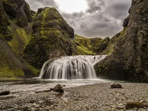 Photo art by Christina Baumgartner: green sphinx in valley with waterfall and mountains