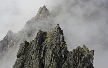 Photo art by Martin Kensy: fog envelops the peaks of mountains in Switzerland.