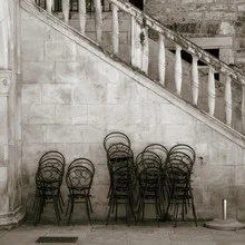 Fotokunst von Ernst Pini: sepiafarbene mediterrane Stühle vor einer Treppe.