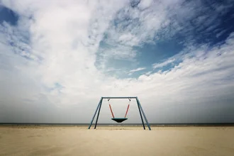 Swing by the sea by Manuela Deigert: calm coastal scene with cloudy sky