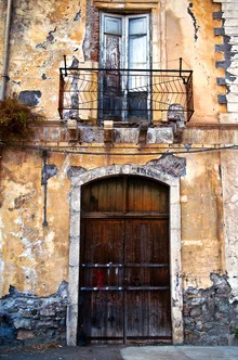 Bunte sizilianische Fassade mit einem Holzfenster und Balkon in Taormina.