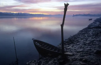 Photo art by Martin Seeliger: calm sunrise over the Lemro River in Myanmar.